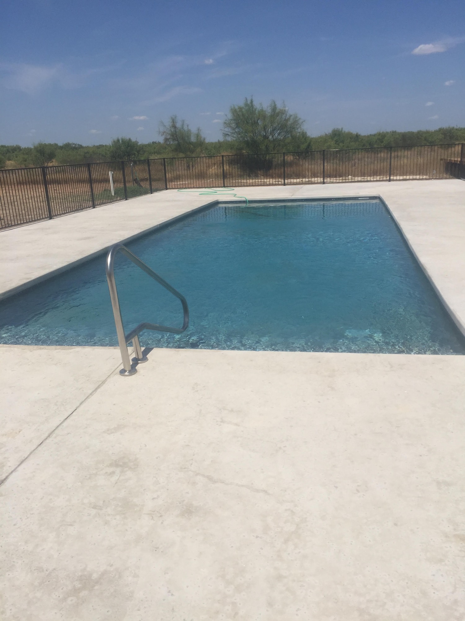 The outdoor swimming pool at Sagebrush Hotel, with its surrounding deck and fenced perimeter