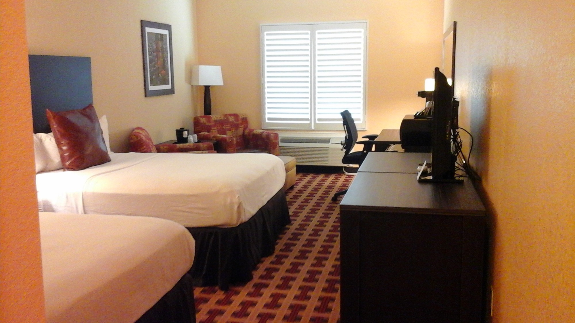 Sagebrush guest room with two beds, bedside lamps, a desk and seating